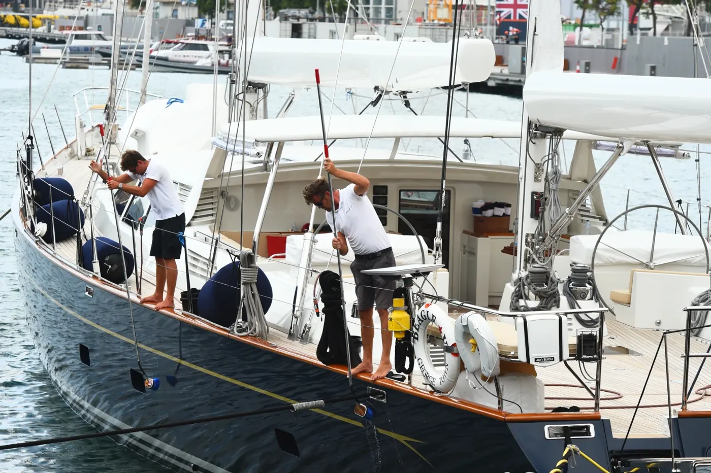 Tripulació preparant un veler amarrat al port