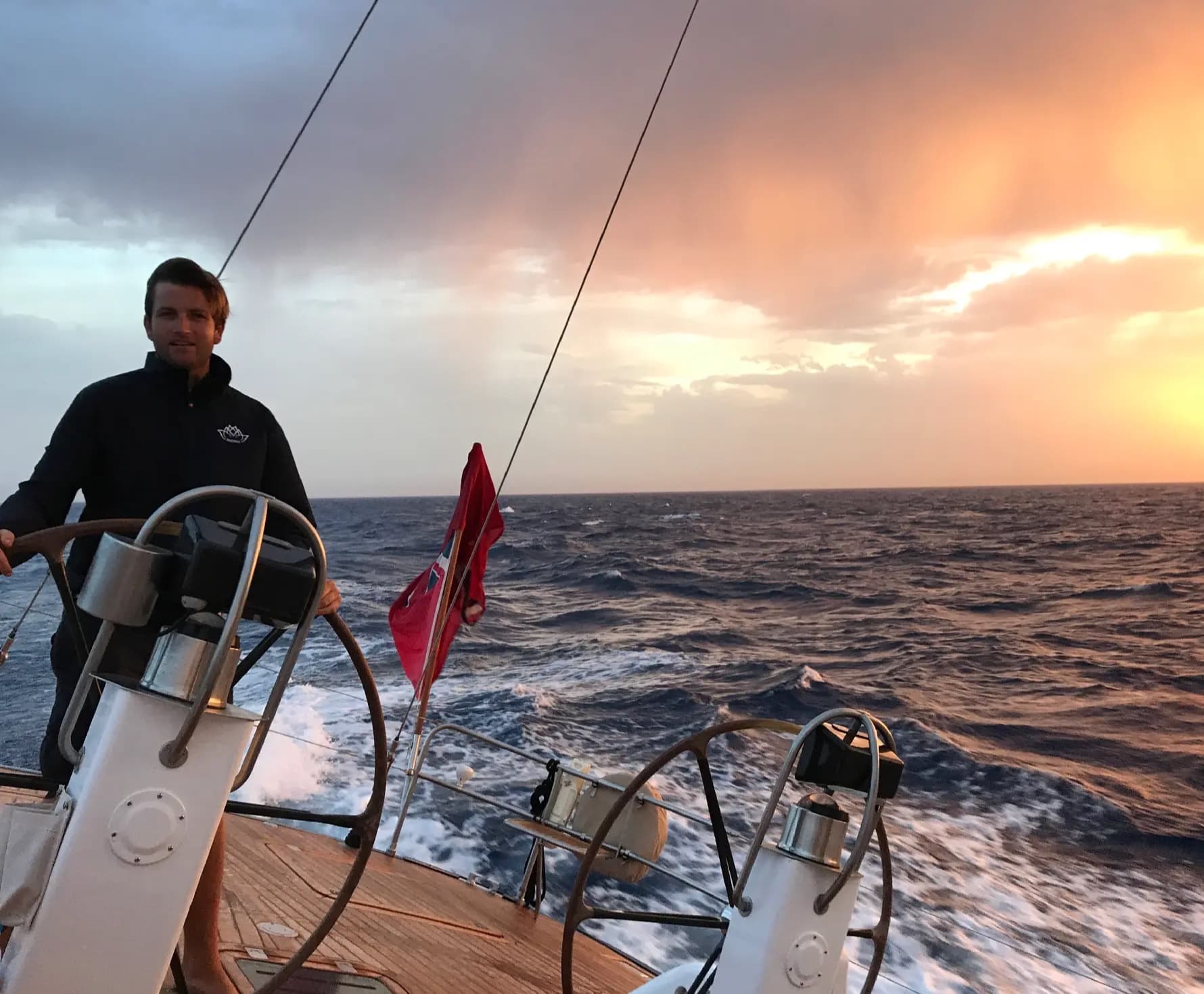 Lawrence Walker al timó d'un superiot de vela a la posta de sol